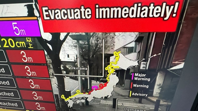 This image taken in Hong Kong on January 1, 2024 shows a warning message on a screen from a live feed on NHK World asking people to evacuate from the area after a series of major earthquakes hit central Japan.