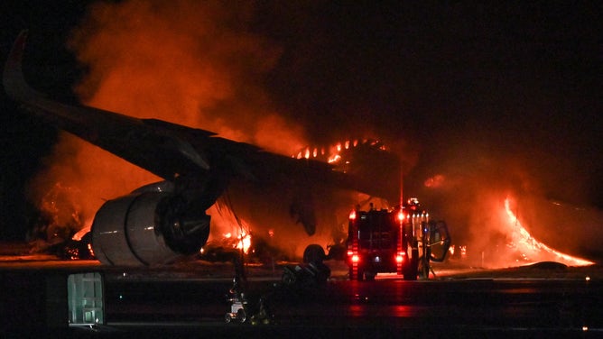 A Japan Airlines (JAL) passenger plane is seen on fire on the tarmac at Tokyo International Airport at Haneda on January 2, 2024. A Japan Airlines plane was in flames on the runway of Tokyo's Haneda Airport on January 2 after apparently colliding with a coast guard aircraft, television reports said. (Photo by Richard A. Brooks / AFP) (Photo by RICHARD A. BROOKS/AFP via Getty Images)