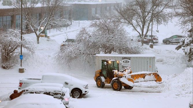 A plow clears the snow from a parking lot as a snowstorm dumps several inches of snow on the area on January 09, 2024 in Des Moines, Iowa.