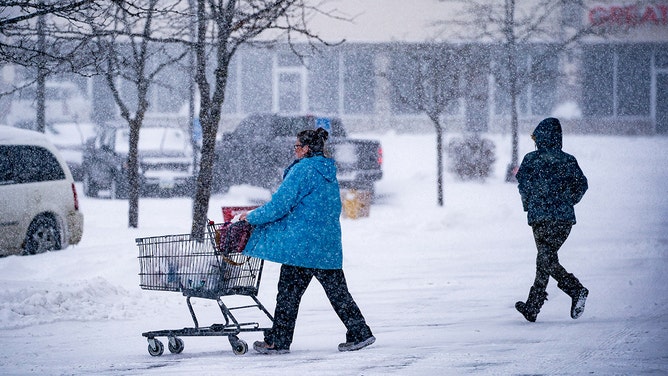 Shoppers exit a grocery store during a winter storm ahead of the Iowa caucus in Des Moines, Iowa, US, on Friday, Jan. 12, 2024.