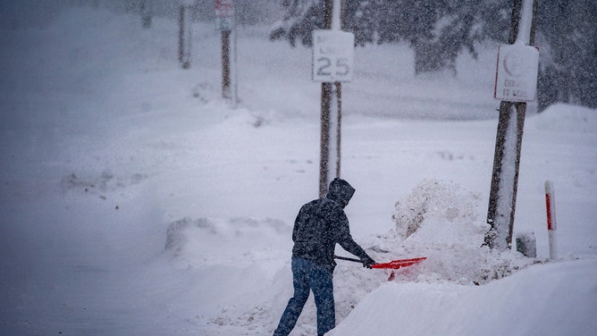 A resident shovels snow during a winter storm ahead of the Iowa caucus in Des Moines, Iowa, US, on Friday, Jan. 12, 2024.