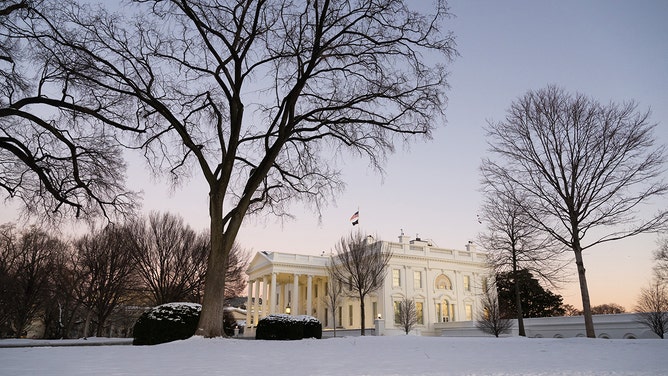 Snow blankets the North Lawn of the White House in Washington, DC, at sunset on January 17, 2024.