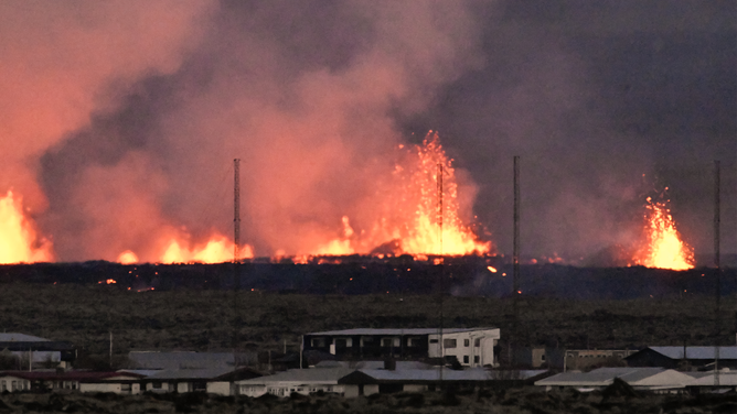 Lava explosions are seen near residential buildings in the southwestern Icelandic town of Grindavik after a volcanic eruption on January 14, 2024. Seismic activity had intensified overnight and residents of Grindavik were evacuated, Icelandic public broadcaster RUV reported. This is Iceland's fifth volcanic eruption in two years, the previous one occurring on December 18, 2023 in the same region southwest of the capital Reykjavik. Iceland is home to 33 active volcano systems, the highest number in Europe. (Photo by Halldor KOLBEINS / AFP) (Photo by HALLDOR KOLBEINS/AFP via Getty Images)