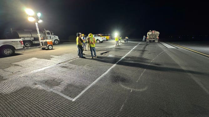 Crews assess a large crack in the runway at Ellison Onizuka Kona International Airport. 