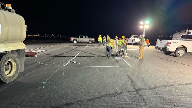 Crews assess a large crack in the runway at Ellison Onizuka Kona International Airport. 