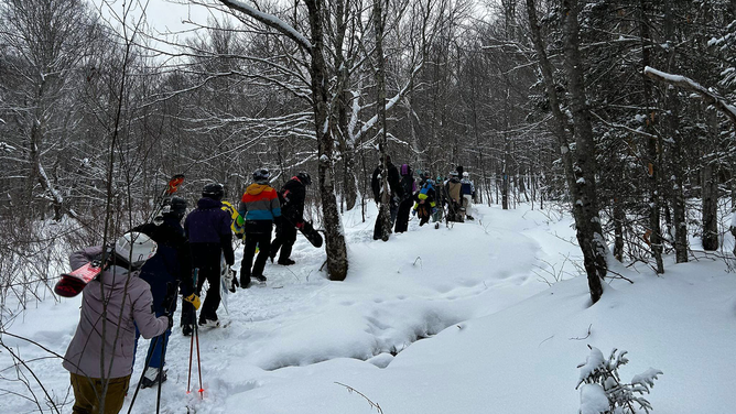 A groupe of skiers and snowboarders is seen being led to safety after getting lost in the Vermont backcountry on Saturday, Jan. 20, 2024.