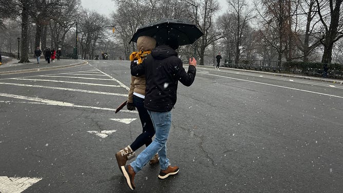 People walk through snow flakes in New York City, New York, during a nor'easter Jan. 6, 2024.