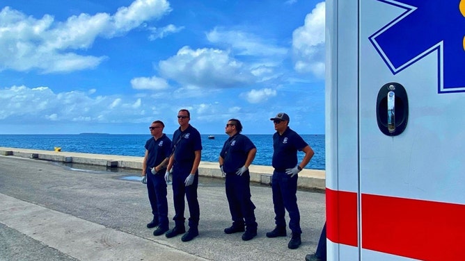 Kwajalein Emergency Management Technicians await the arrival of the catamaran bringing 80 Roi-Namur residents displaced to Kwajalein after a night of flooding waves.