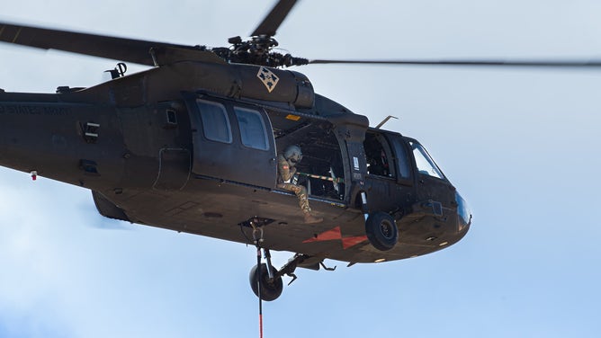 A helicopter performs a water drop on the West Monument Creek Fire in Colorado Springs, Colorado on February 26, 2024.