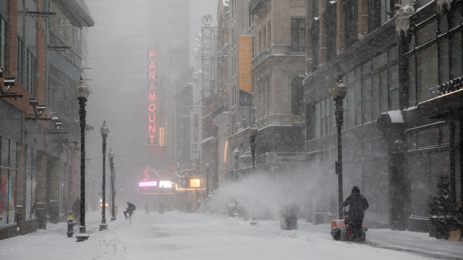 FILE - Workers remove snow in the Downtown Crossing area of Boston on January 29, 2022. (Photo by Scott Eisen/Getty Images)