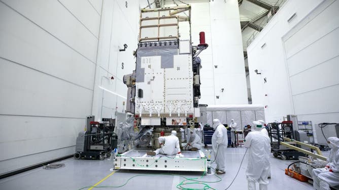 Technicians monitor movement and guide NOAA’s Geostationary Operation Environmental Satellite-U (GOES-U) as a crane hoists it on to a spacecraft dolly in a high bay at the Astrotech Space Operations Facility near the agency’s Kennedy Space Center in Florida.