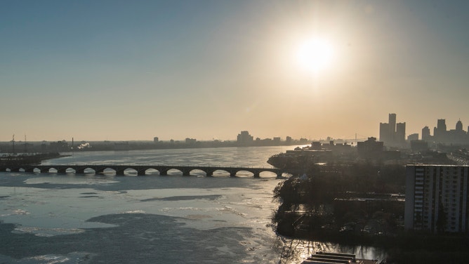 14 January 2019, US, Detroit: Ice floes float across the Detroit River as the sun sets over the rooftops of the city. Photo: Boris Roessler/dpa (Photo by Boris Roessler/picture alliance via Getty Images)