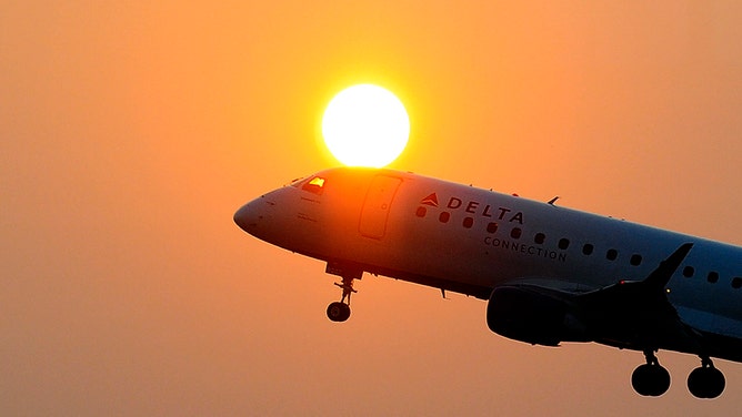 A Delta airline's aircraft takes off from the Ronald Reagan National airport as the sun rises in Washington, DC, on June 9, 2011.