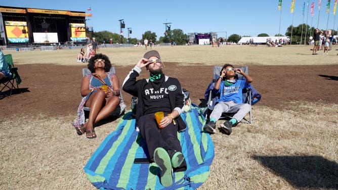 Festival goers watch the solar eclipse before the music starts during the 2023 Austin City Limits Music Festival at Zilker Park on October 14, 2023 in Austin, Texas.