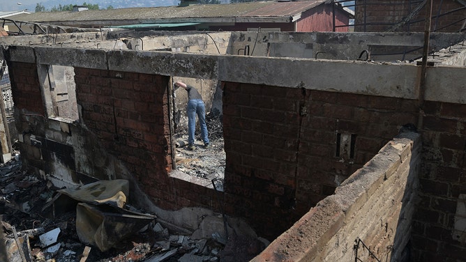 A man is seen inside a burnt house after a fire that affected the hills in Quilpue comune, Viña del Mar, Chile on February 3, 2024.
