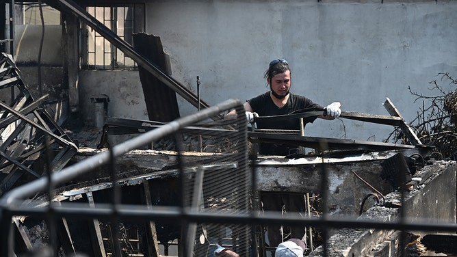 A man cleans his house after a fire that affected the hills in Quilpue comune, Viña del Mar, Chile on February 3, 2024.