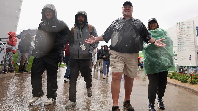 Fans walk through the rain during a weather delay at the Pro-am to the WM Phoenix Open at TPC Scottsdale on February 07, 2024 in Scottsdale, Arizona.