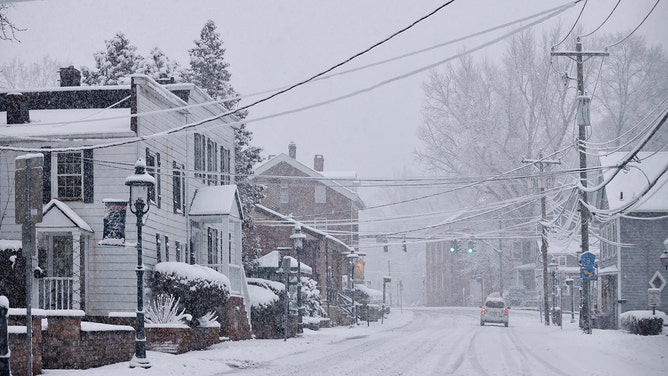 A car drives along Main Street as snow falls in Tappan, New York on February 10, 2024.