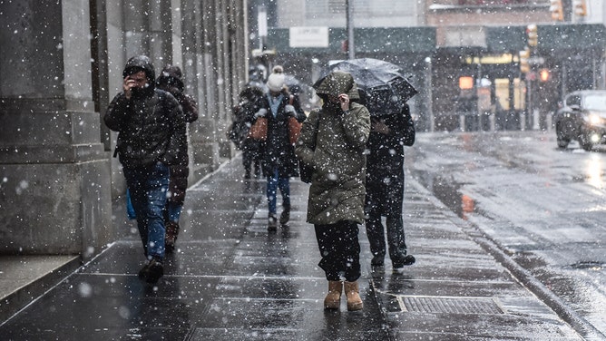 Pedestrians walk through the snow during a storm in New York, US, on Tuesday, Feb. 13, 2024.