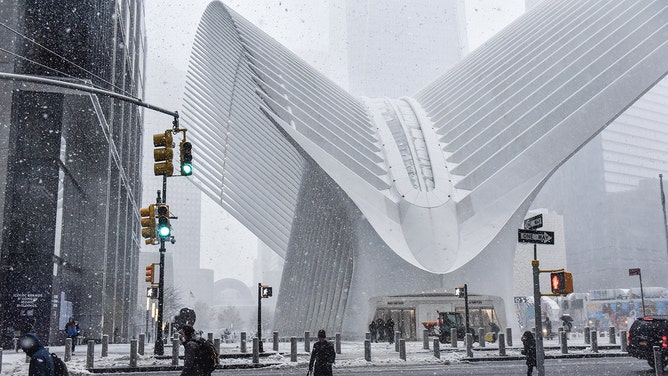 Pedestrians walk through the snow near the Oculus transportation hub during a storm in New York, US, on Tuesday, Feb. 13, 2024.