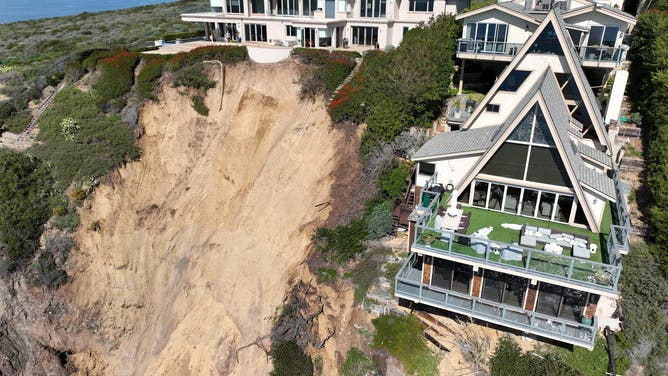 Aerial view of three large homes in Dana Point that are in danger of falling into the ocean after a cliffside gave way over the weekend.