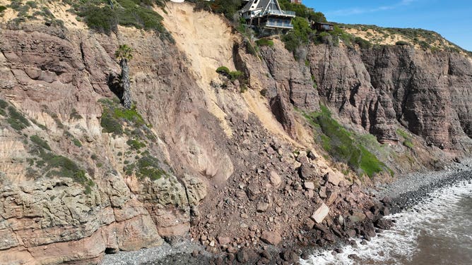 Aerial view of three large homes in Dana Point that are in danger of falling into the ocean after a cliffside gave way over the weekend.