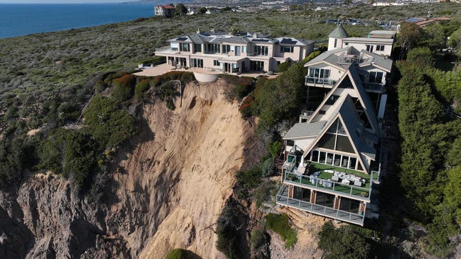 Aerial view of three large homes in Dana Point that are in danger of falling into the ocean after a cliffside gave way over the weekend.