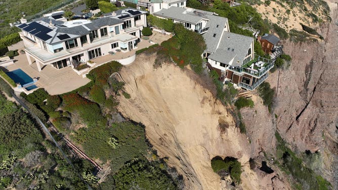 Aerial view of three large homes in Dana Point that are in danger of falling into the ocean after a cliffside gave way over the weekend.