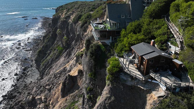 Aerial view of three large homes in Dana Point that are in danger of falling into the ocean after a cliffside gave way over the weekend.