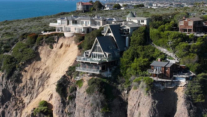 Aerial view of three large homes in Dana Point that are in danger of falling into the ocean after a cliffside gave way over the weekend.