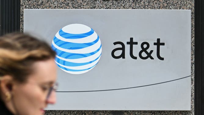 A woman walks past signage for AT&amp;T in Washington, DC, on February 22, 2024. Nearly 75,000 AT&amp;T customers reported cell phone service outages on February 22, 2024, according to tracking website Downdetector. The issue was clustered in several cities, including Dallas, Houston, Chicago, Atlanta and Miami, the website said. (Photo by Mandel NGAN / AFP)