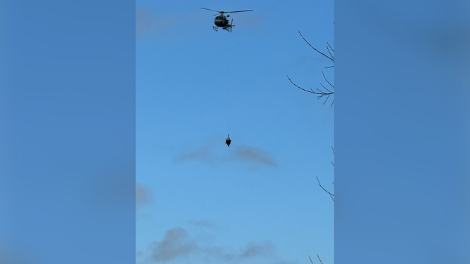 A photo showing rescuers hoist a flood victim to safety on Monday, Feb. 19, 2024.