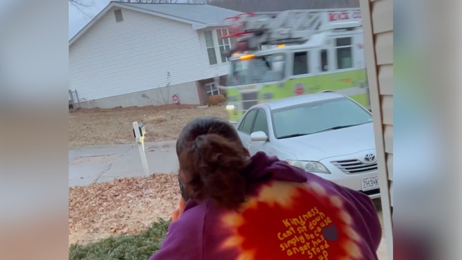 A woman looks on as the fire truck spins. Jan. 22, 2024.