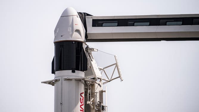 A SpaceX Dragon spacecraft in front of the blue sky in Florida at Kennedy Space Center.