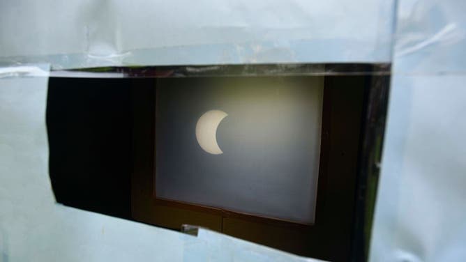 A partially eclipsed sun is reflected on a pinhole camera set up at India Gate, on June 21, 2020 in New Delhi, India.