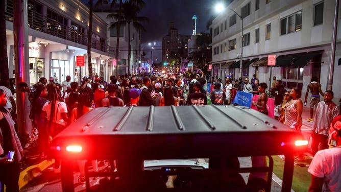 Miami Beach Police escort revelers as they gather on Ocean Drive in Miami Beach, Florida on March 15, 2022. - Music, dancing, alcohol and tiny swimsuits -- spring vacation in the United States, popularly known as "spring break," brings thousands of young people to south Florida every year for a few days of uncontrolled fun, much to the chagrin of residents in cities like Miami Beach. (Photo by CHANDAN KHANNA / AFP) (Photo by CHANDAN KHANNA/AFP via Getty Images)