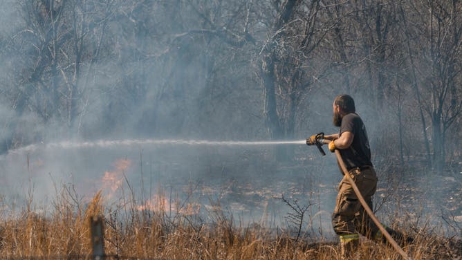 A firefighter extinguishes hotspots following the Smokehouse Creek Fire in Miami, Texas, US, on Saturday, March 2, 2024. Texas emergency crews are battling the worst wildfire in state history amid forecasts for several more days of dry, windy weather that will make their task more difficult. Photographer: Jordan Vonderhaar/Bloomberg via Getty Images