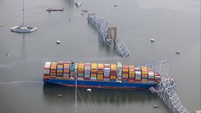 In an aerial view, cargo ship Dali is seen after running into and collapsing the Francis Scott Key Bridge on March 26, 2024 in Baltimore, Maryland. Rescuers are searching for at least seven people, authorities say, while two others have been pulled from the Patapsco River.