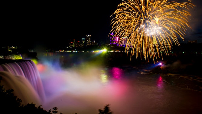 Fireworks set off from the Canadian side light up the sky over Niagra Falls late July 3, 2016, part of the July 4th US Independence Day celebrations, in Niagra Falls, New York.