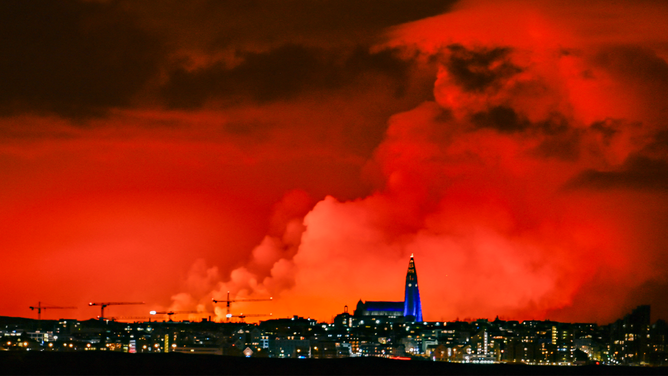 The skyline of Reykjavik is against the backdrop of orange coloured sky due to molten lava flowing out from a fissure on the Reykjanes peninsula north of the evacuated town of Grindavik, western Iceland on March 16, 2024. Lava spewed Saturday from a new volcanic fissure on Iceland's Reykjanes peninsula, the fourth eruption to hit the area since December, authorities said. (Photo by Halldor KOLBEINS / AFP) (Photo by HALLDOR KOLBEINS/AFP via Getty Images)