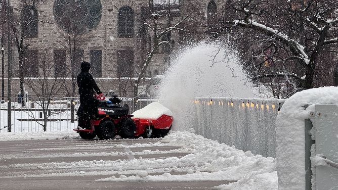 This photo shows someone working to remove snow that fell in Minneapolis on Monday, March 25, 2024.