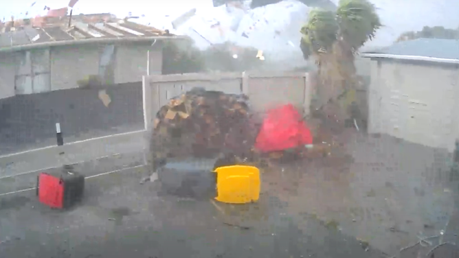 A screenshot from security video shows the roof of a home in New Zealand being pulled away during severe thunderstorms on Monday, March 11, 2024.