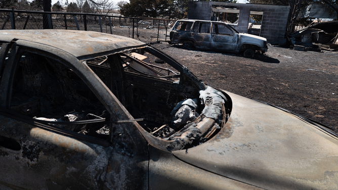 STINNETT, TEXAS - MARCH 02: Charred remains of automobiles sit behind a home that was destroyed by the Smokehouse Creek fire when it burned its way through town last Tuesday on March 02, 2024 in Stinnett, Texas. The fire has burned more than a million acres in the Texas Panhandle, killing at least two people and destroying more than 500 structures. (Photo by Scott Olson/Getty Images)