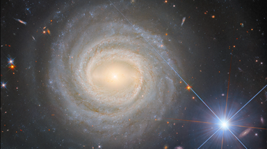 Hubble telescope reveals illusionary tale of spiral galaxy and bright star