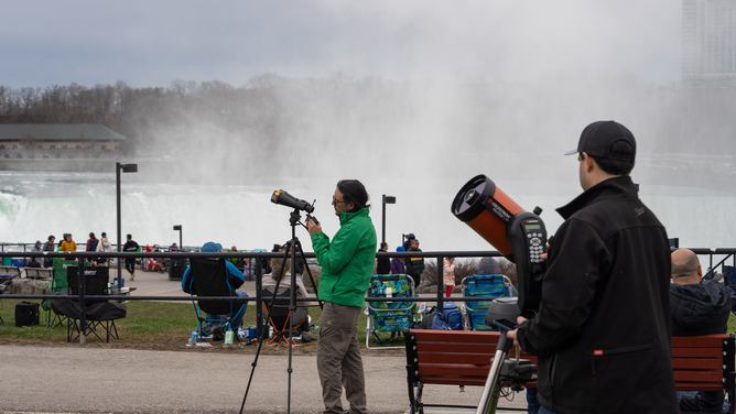 NIAGARA FALLS, NEW YORK - APRIL 8: People set up their binoculars and telescopes ahead of the Solar Eclipse on April 8, 2024 in Niagara Falls, New York. Millions of people have flocked to areas across North America that are in the "path of totality" in order to experience a total solar eclipse. During the event, the moon will pass in between the sun and the Earth, appearing to block the sun. (Photo by Adam Gray/Getty Images)