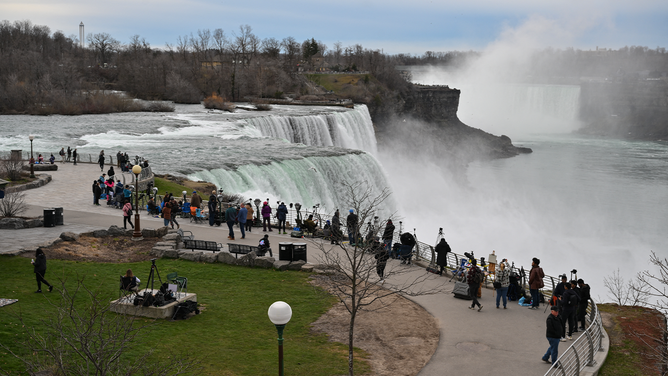 People gather at Niagara Falls State Park ahead of a total solar eclipse across North America, in Niagara Falls, New York, on April 8, 2024. This year's path of totality is 115 miles (185 kilometers) wide and home to nearly 32 million Americans, with an additional 150 million living less than 200 miles from the strip. The next total solar eclipse that can be seen from a large part of North America won't come around until 2044. (Photo by ANGELA WEISS / AFP) (Photo by ANGELA WEISS/AFP via Getty Images)