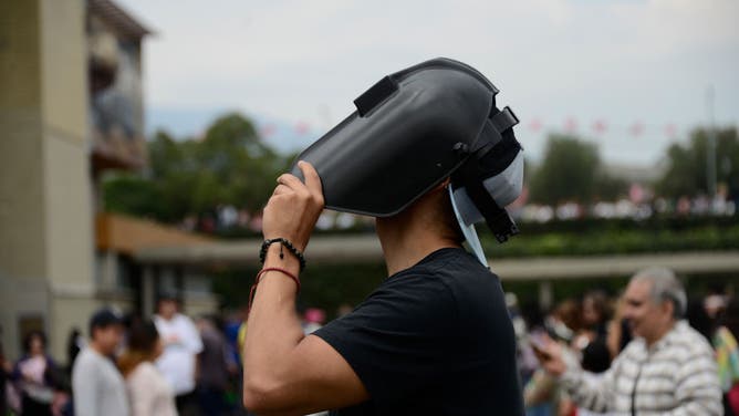 A man watches the Annular Solar Eclipse with a welding mask at the National Autonomous University of Mexico (UNAM)