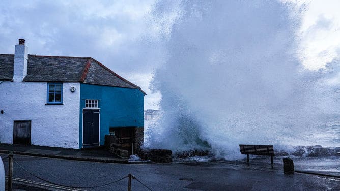 Waves crash over the harbour wall onto the street on April 9, 2024 in St Ives, Cornwall, England.