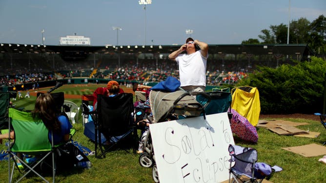 ans watch the eclipse during the 2017 Little League World Series at Lamade Stadium on Monday, August 21, 2017 in South Williamsport, Pennsylvania.