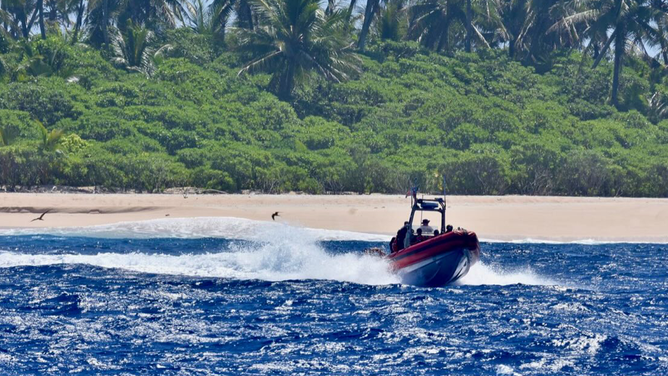 The image shows the U.S. Coast Guard near the beach of a remote Pacific island where the stranded sailors were rescued.